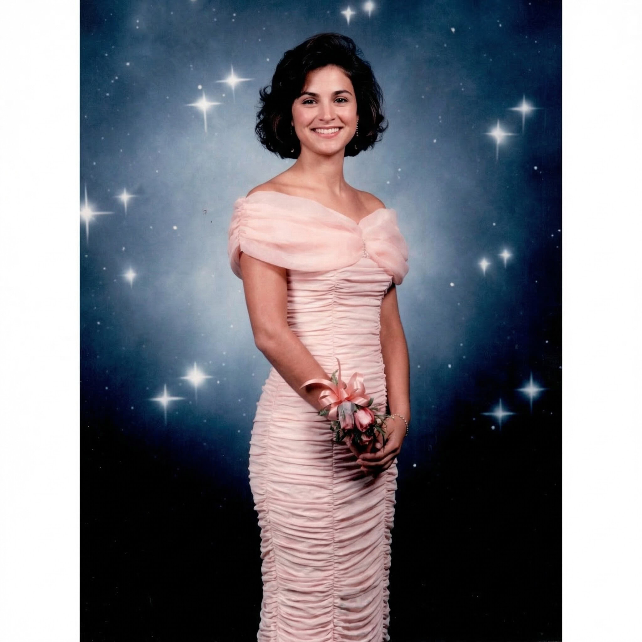 Woman in pink evening gown holding flowers at SF Booths event.